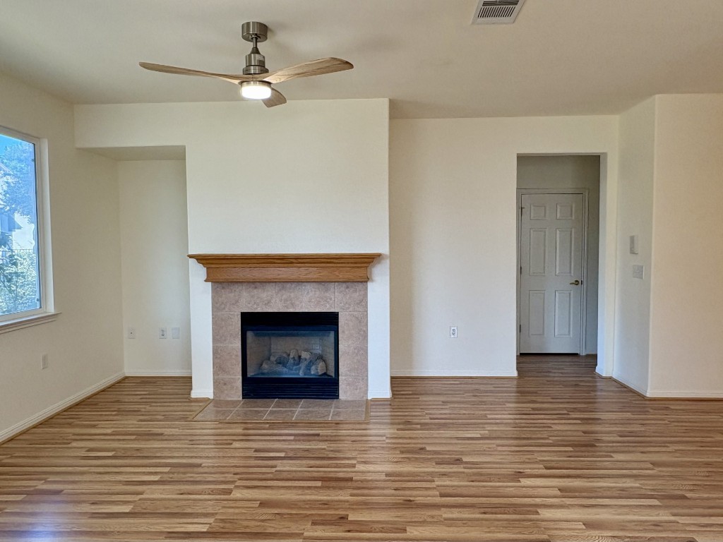 106 Prospector Pass Georgetown, TX 78633 - Photo 4 of 14 a view of an empty room with wooden floor and a fireplace