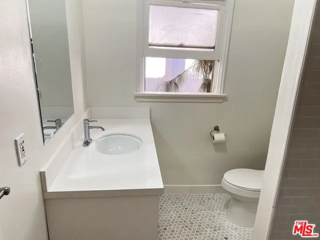 a bathroom with a sink a toilet and a mirror