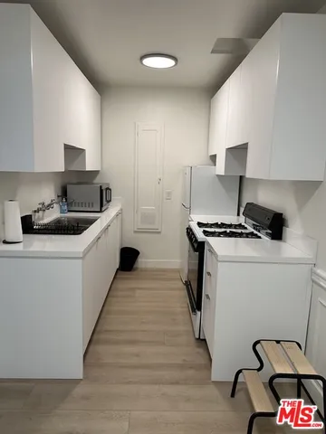 a kitchen with a sink a stove and cabinets