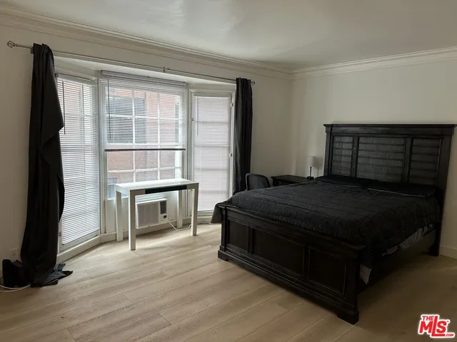 a living room with a bed furniture and a flat screen tv
