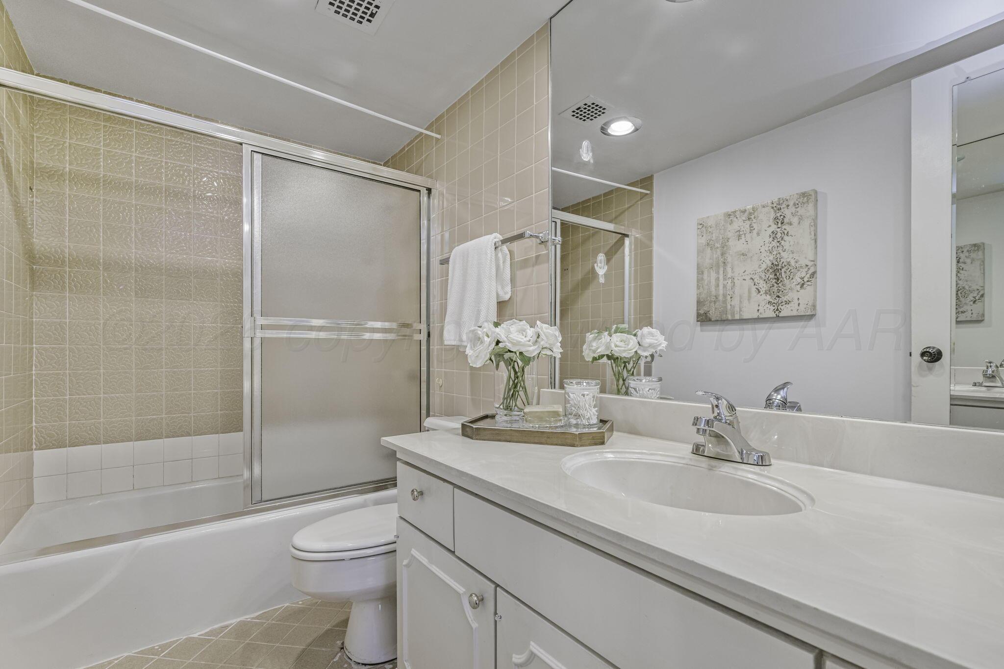 2028 South Austin Street, Unit 902 Amarillo, TX 79109 - Photo 15 of 23 a bathroom with a sink a toilet and shower