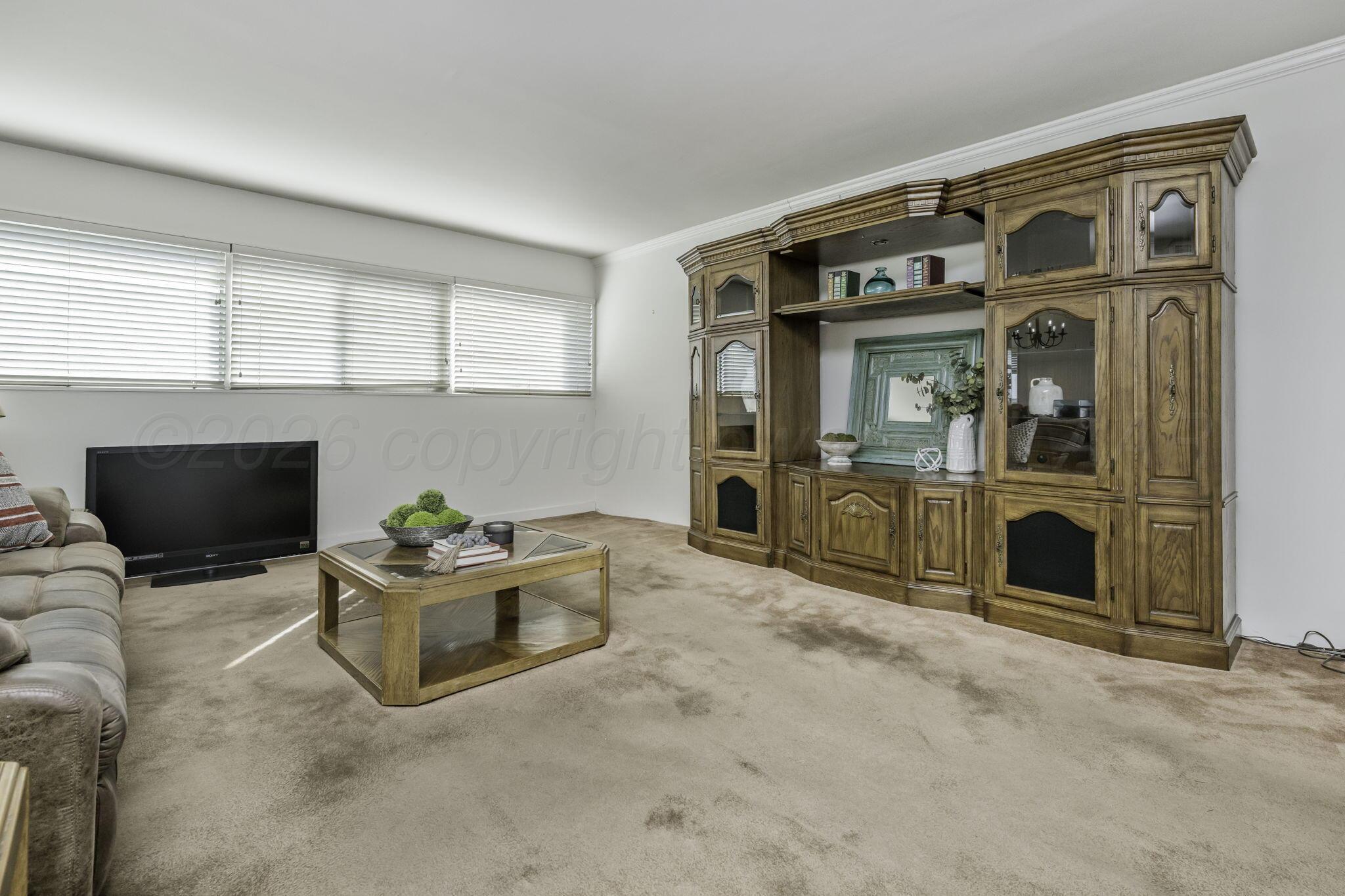 2028 South Austin Street, Unit 902 Amarillo, TX 79109 - Photo 2 of 23 a living room with a fireplace and a flat screen tv