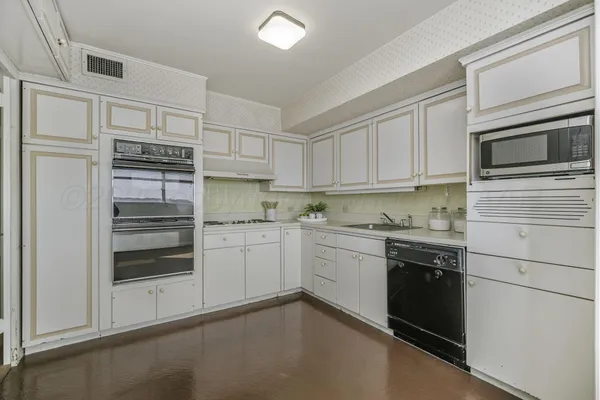 a kitchen with granite countertop white cabinets and stainless steel appliances