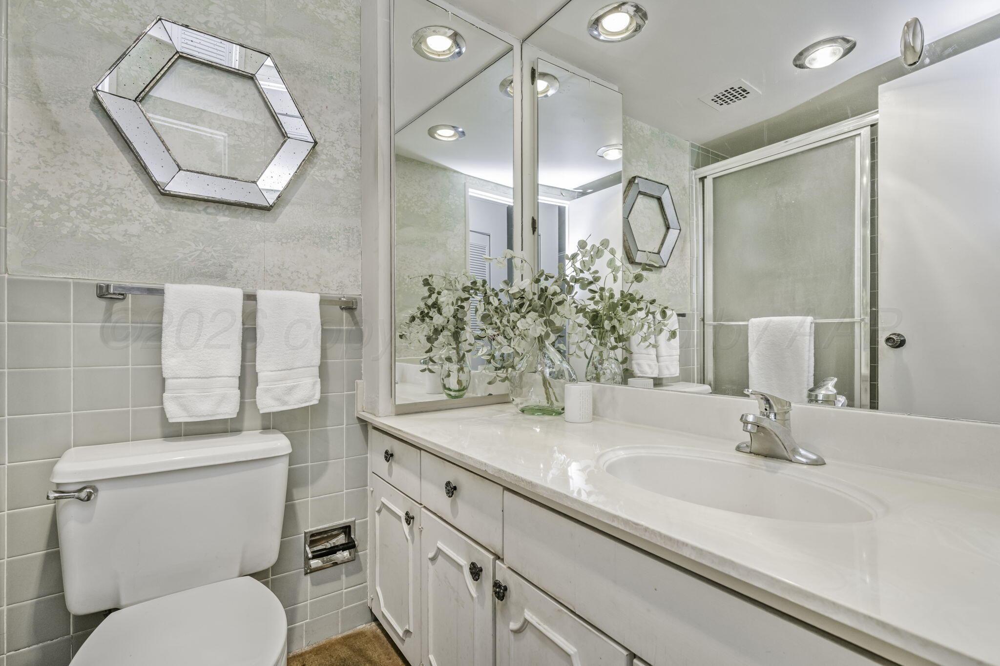 2028 South Austin Street, Unit 902 Amarillo, TX 79109 - Photo 9 of 23 a bathroom with a granite countertop sink mirror and toilet
