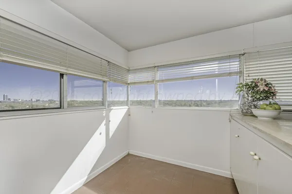 an empty room with windows and fan