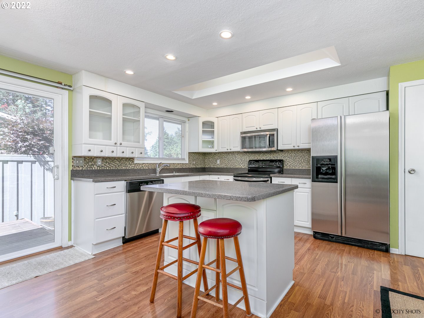 37260 Dubarko Road Sandy, OR 97055 - Photo 13 of 32 a kitchen with stainless steel appliances granite countertop a refrigerator a stove top oven a sink dishwasher and white cabinets with wooden floor
