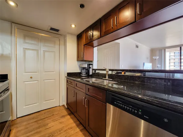 a kitchen with stainless steel appliances granite countertop a sink and wooden cabinets