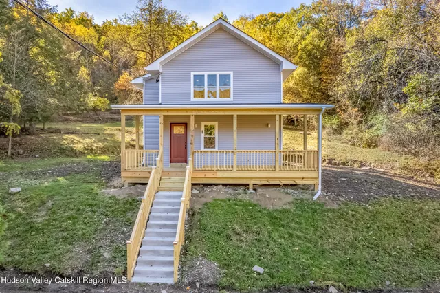 a front view of a house with yard and green space