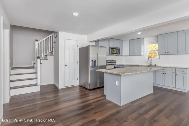 a kitchen with granite countertop a refrigerator and a sink