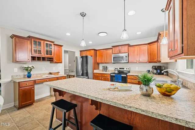a kitchen with stainless steel appliances granite countertop a sink a stove and a wooden floors