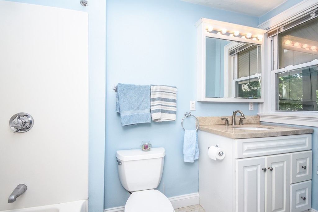 25 Wellington Street, Unit 1 Waltham, MA 02451 - Photo 16 of 18 a bathroom with a granite countertop sink mirror vanity and toilet
