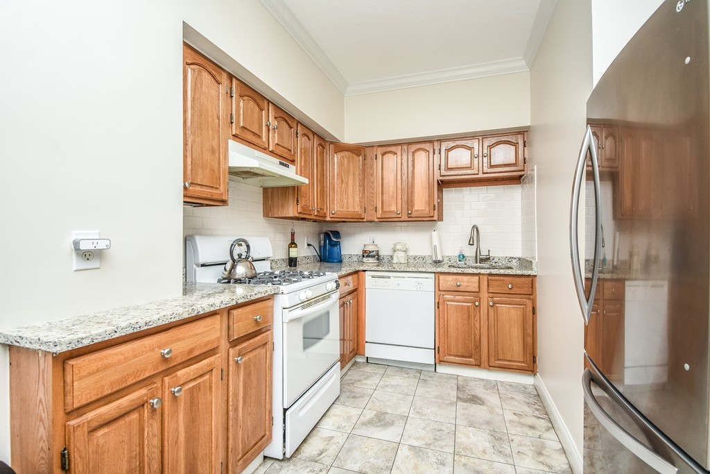 25 Wellington Street, Unit 1 Waltham, MA 02451 - Photo 4 of 18 a kitchen with stainless steel appliances granite countertop a refrigerator and a sink