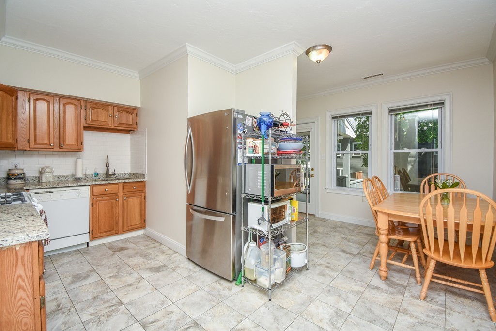 25 Wellington Street, Unit 1 Waltham, MA 02451 - Photo 5 of 18 a kitchen with stainless steel appliances granite countertop a refrigerator and a stove top oven