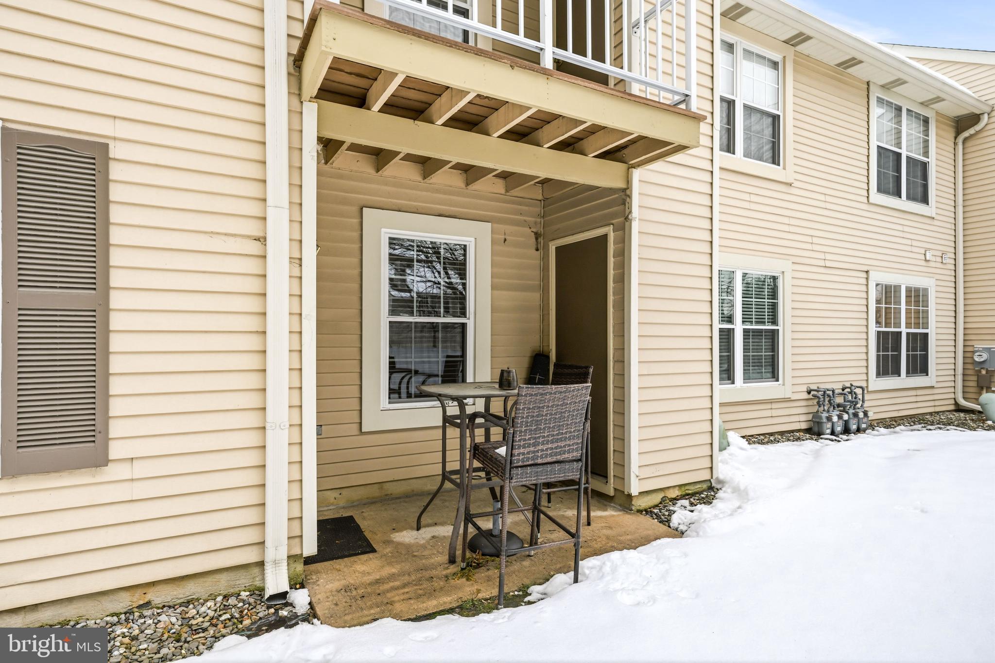 2705A Heatherstone Court Mount Laurel, NJ 08054 - Photo 25 of 29 a view of a patio with a table and chairs and floor to ceiling window