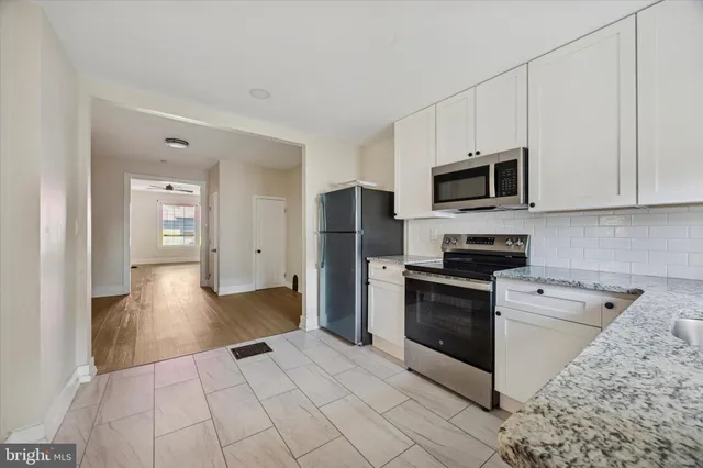 a kitchen with stainless steel appliances granite countertop a refrigerator and a stove top oven