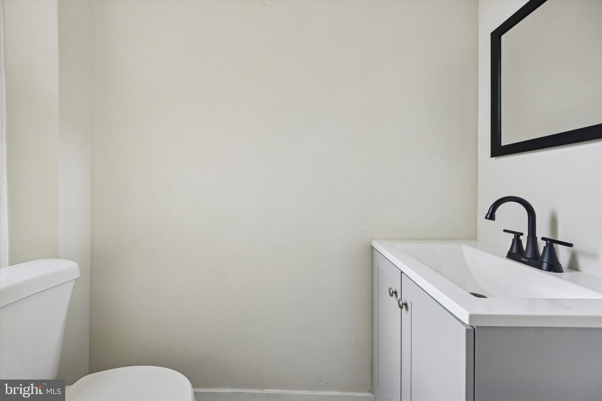 6002 West Thompson Street Philadelphia, PA 19151 - Photo 8 of 15 a bathroom with a sink a toilet and mirror