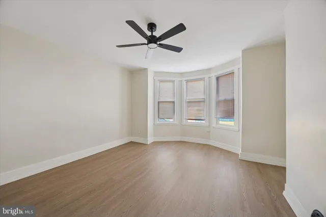 a view of a livingroom with a ceiling fan and wooden floor