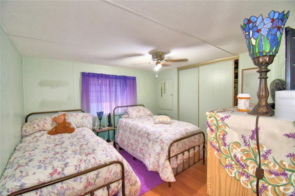 251 Patterson Road, Unit D35 Haines City, FL 33844 - Photo 11 of 37 a bedroom with two beds and a chandelier