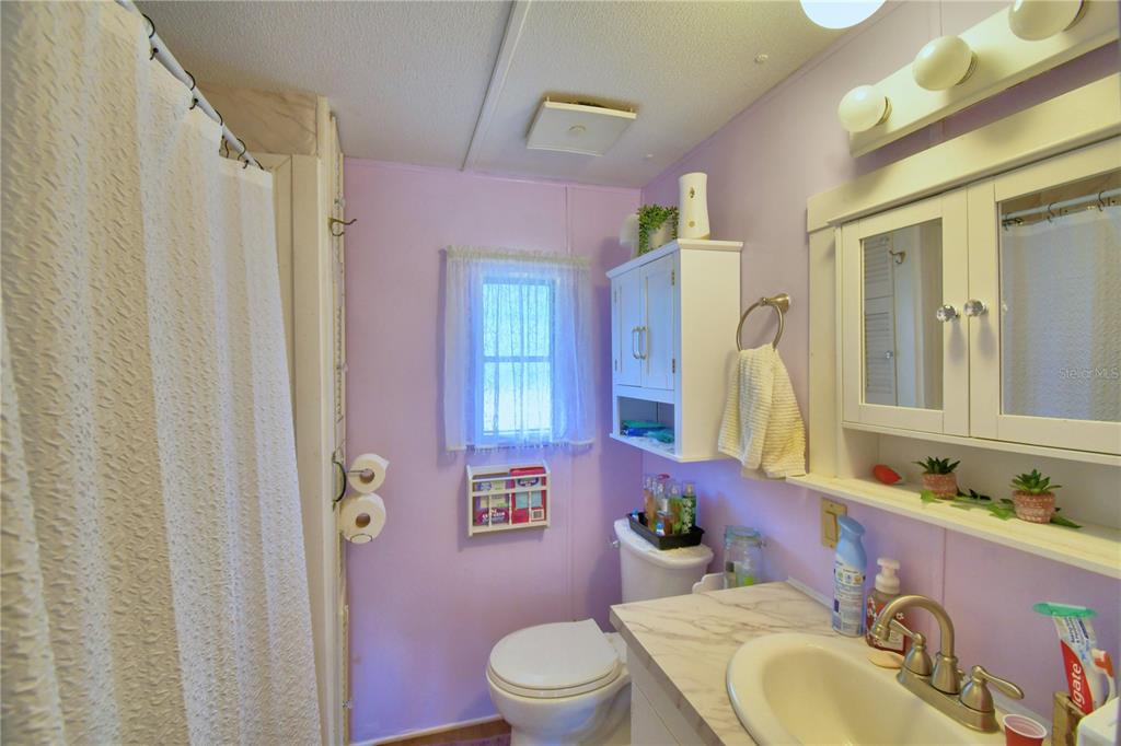 251 Patterson Road, Unit D35 Haines City, FL 33844 - Photo 12 of 37 a bathroom with a granite countertop sink vanity mirror and toilet