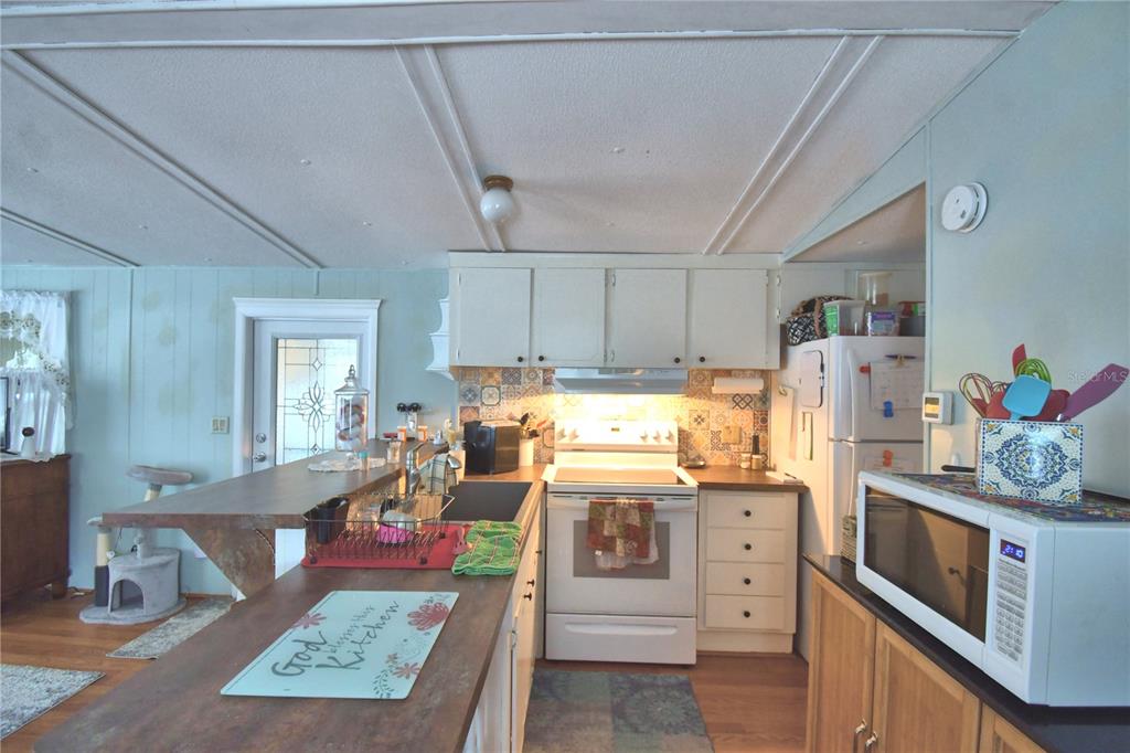 251 Patterson Road, Unit D35 Haines City, FL 33844 - Photo 15 of 37 a kitchen with stainless steel appliances granite countertop a stove a sink dishwasher and cabinets with wooden floor