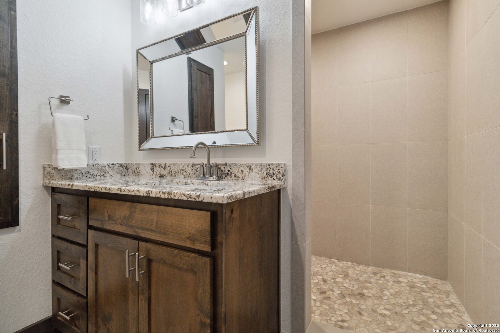 3293 North Little Creek Road Utopia, TX 78884 - Photo 13 of 65 a bathroom with a granite countertop sink and a mirror