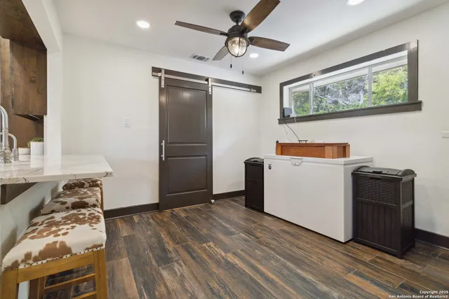 a living room with furniture a flat screen tv and kitchen view