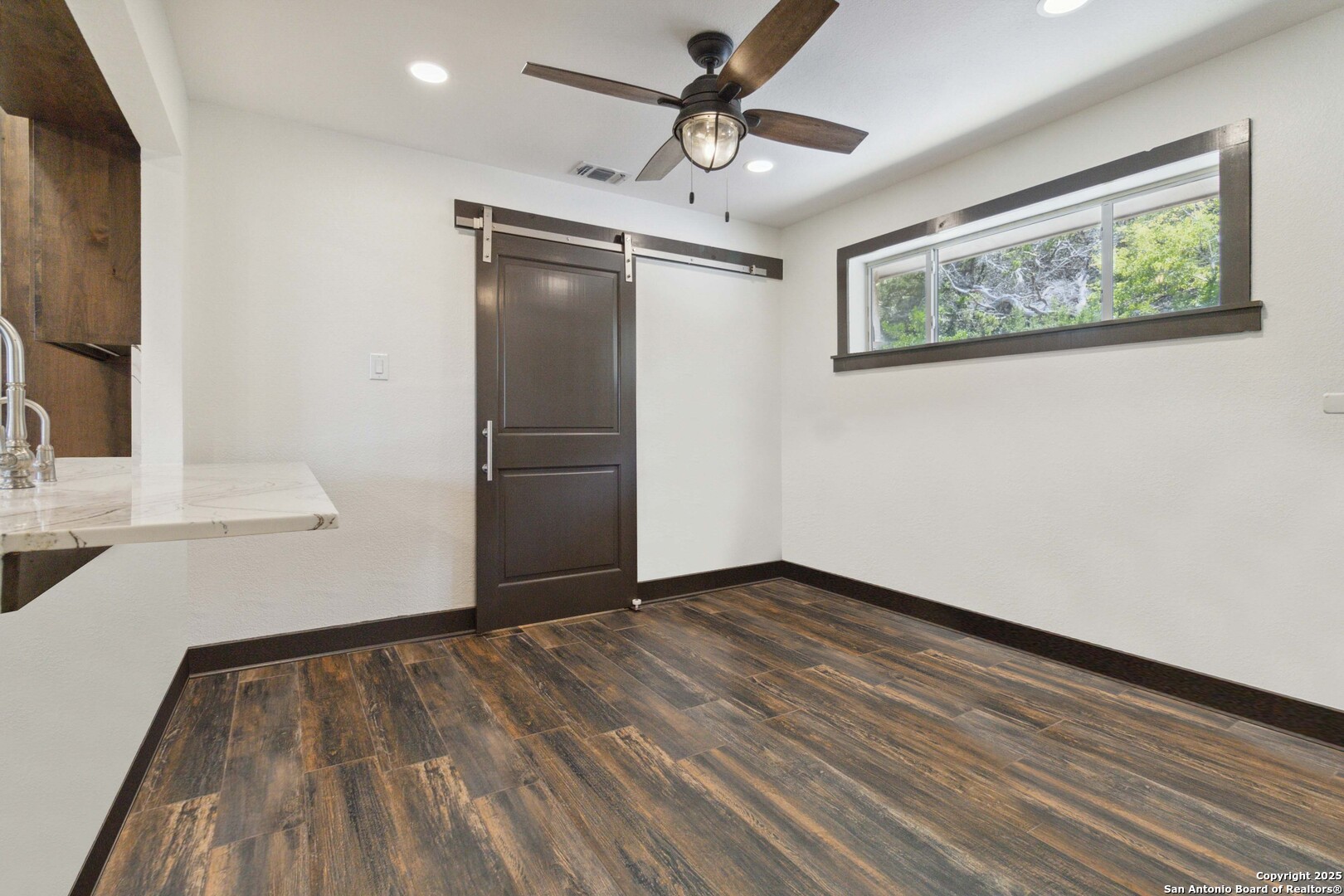 3293 North Little Creek Road Utopia, TX 78884 - Photo 25 of 65 a view of an empty room with wooden floor and a window