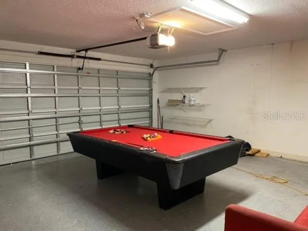 a room with pool table and windows