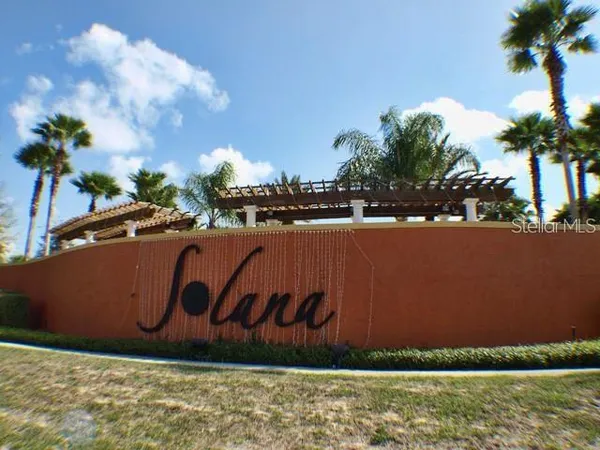 a front view of a multi story residential apartment building with yard and outdoor seating