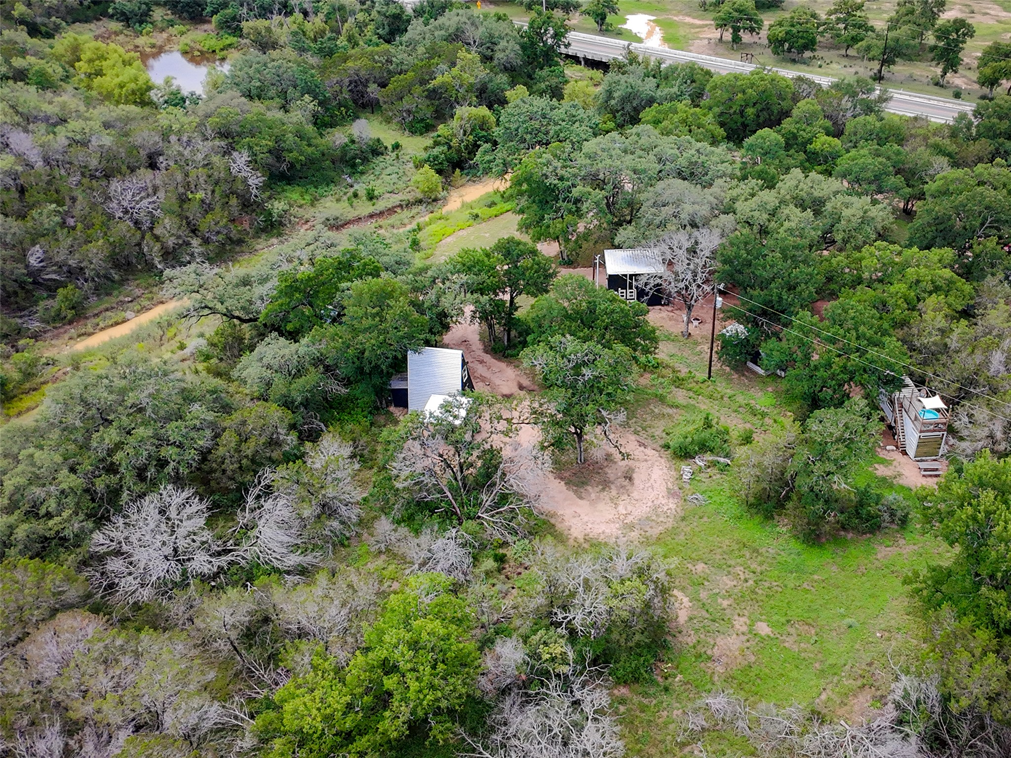 an aerial view of residential house with outdoor space and trees all around