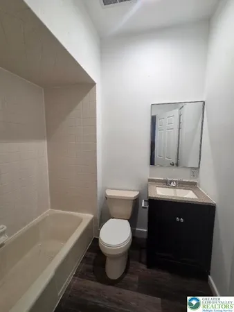 a bathroom with a granite countertop toilet a sink and bathtub