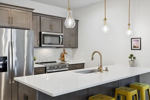a kitchen with kitchen island a counter top space appliances and cabinets