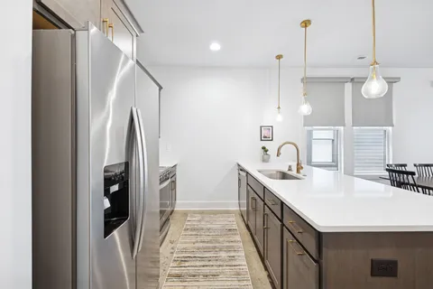 a kitchen with kitchen island a sink a counter and a refrigerator