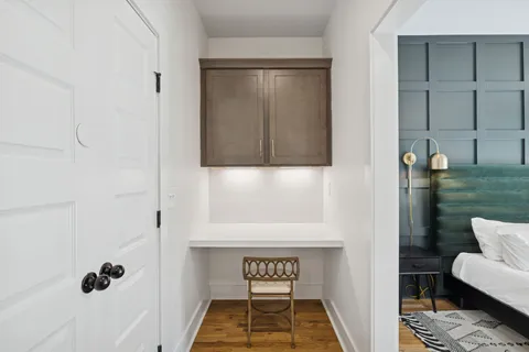 a hallway with a white cabinets and wooden floor