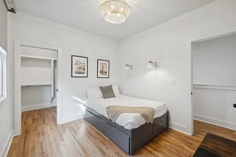 a bedroom with a bed and a chandelier