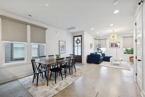 a view of a dining room and livingroom with furniture a rug a glass table and chairs