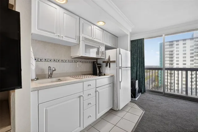a living room with stainless steel appliances granite countertop furniture and a couch