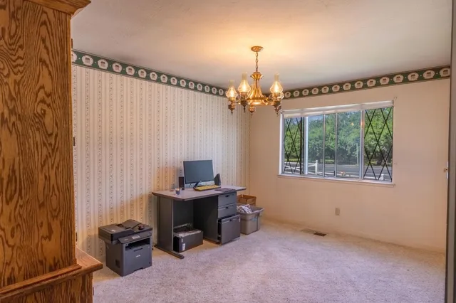 a view of a workspace with furniture and a window