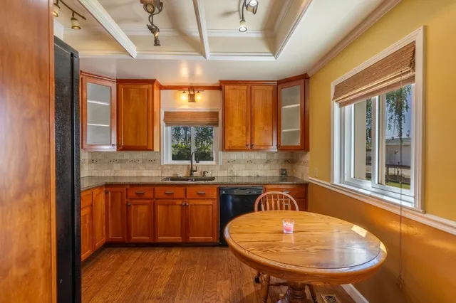 a kitchen with sink a window and chairs