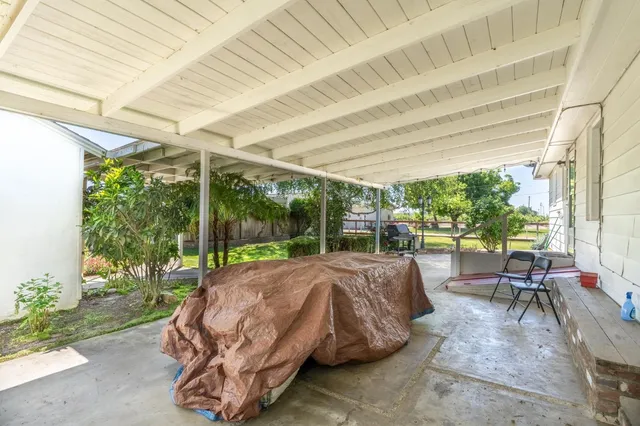 a bed sitting in a bedroom next to a large window with yard in front of it