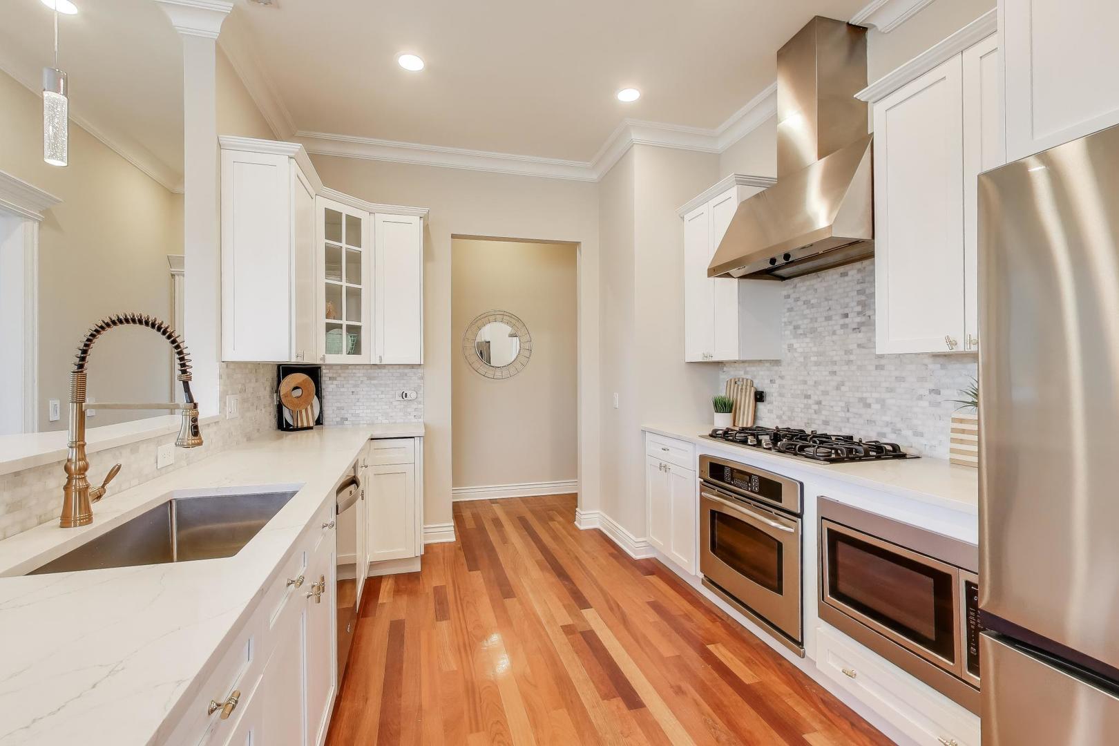 1148 West Monroe Street, Unit 5NE Chicago, IL 60607 - Photo 8 of 21 a kitchen with stainless steel appliances a stove a sink a refrigerator and cabinets