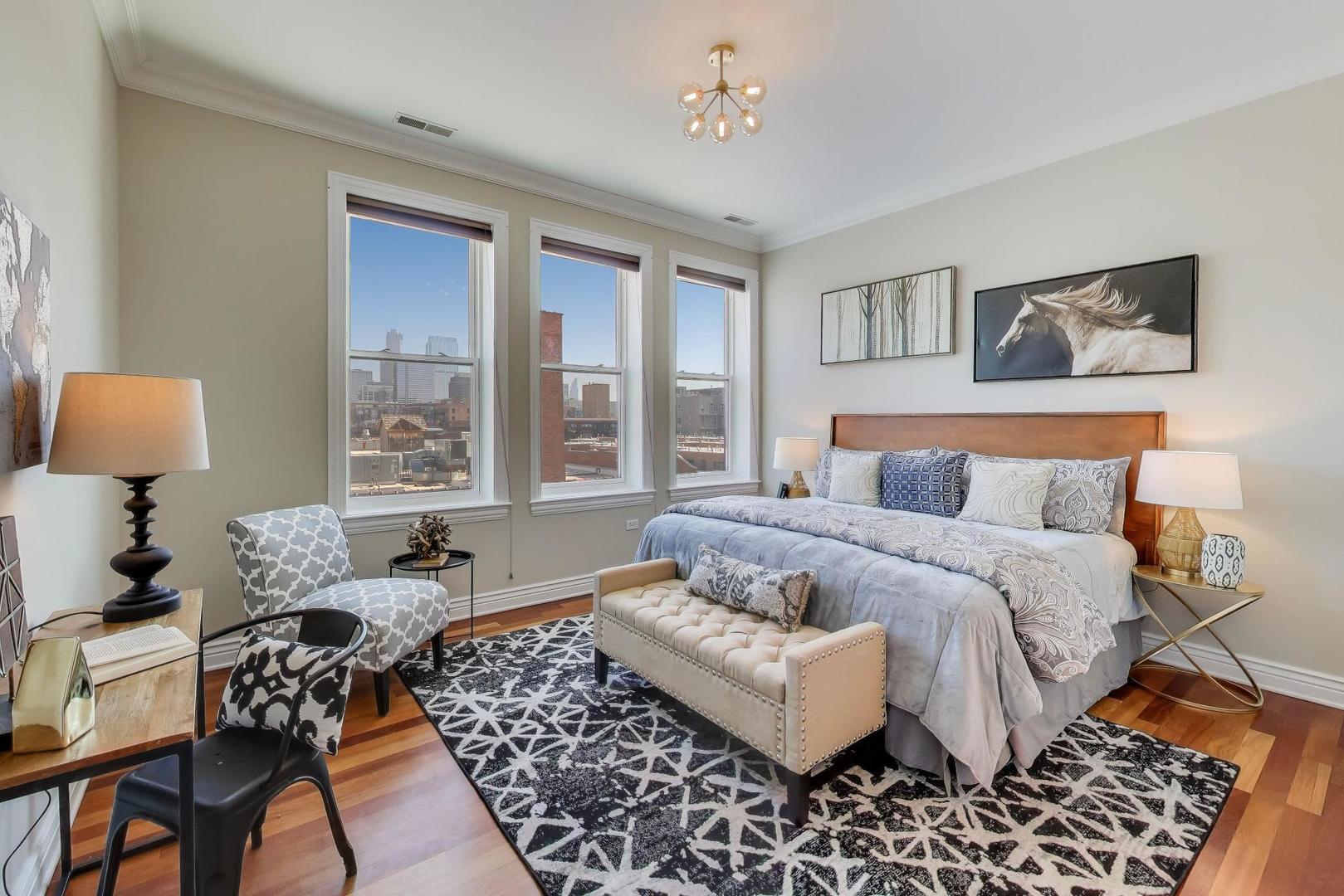 1148 West Monroe Street, Unit 5NE Chicago, IL 60607 - Photo 9 of 21 a bedroom with a bed and wooden floor