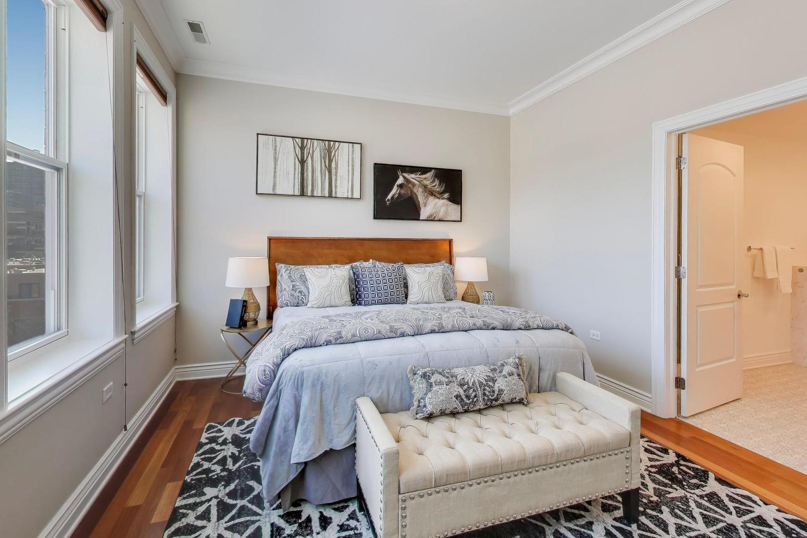 1148 West Monroe Street, Unit 5NE Chicago, IL 60607 - Photo 10 of 21 a bedroom with a bed and wooden floor