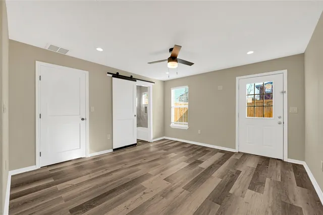 a view of a room with wooden floor and a ceiling fan