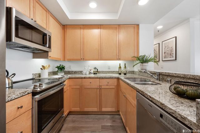 a kitchen with stainless steel appliances granite countertop a sink stove microwave and refrigerator
