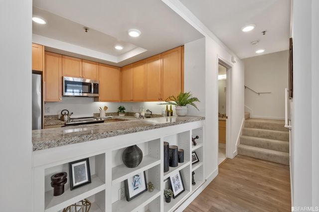 a kitchen with stainless steel appliances granite countertop a stove a sink and a microwave