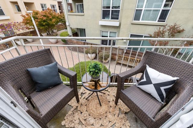 a view of a balcony with two chairs and a potted plant