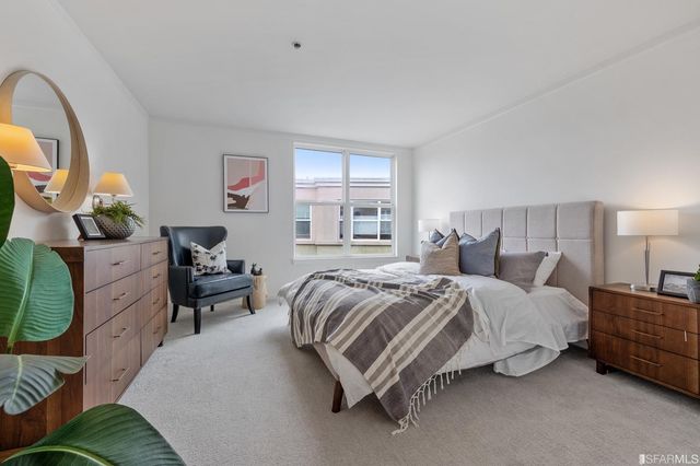 a spacious bedroom with a bed couch and window