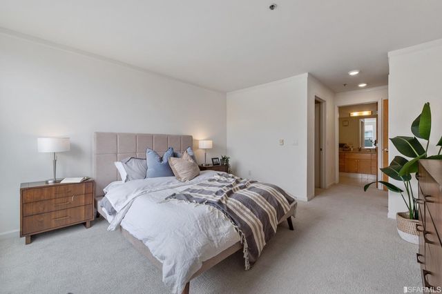 a bedroom with a bed a mirror on dresser and a lamp