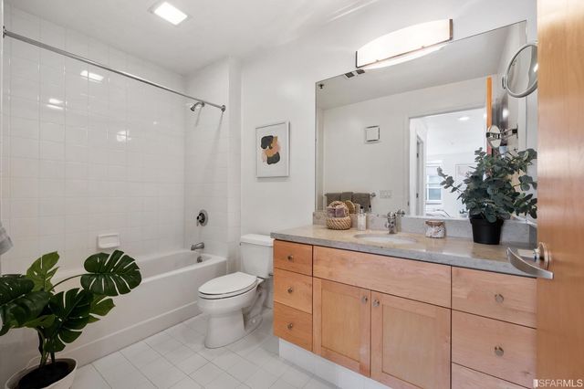 a spacious bathroom with a granite countertop sink a toilet and a mirror